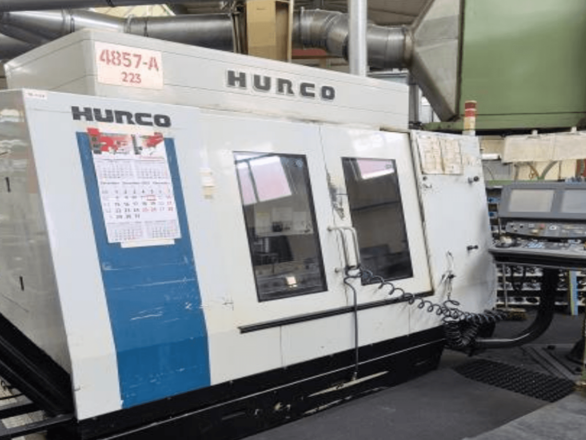 Hurco VMX 42 Vertikal-Bearbeitungszentrum in der Vorderansicht, mit Bedienfeld, Kalender und äußeren Metalldetails.