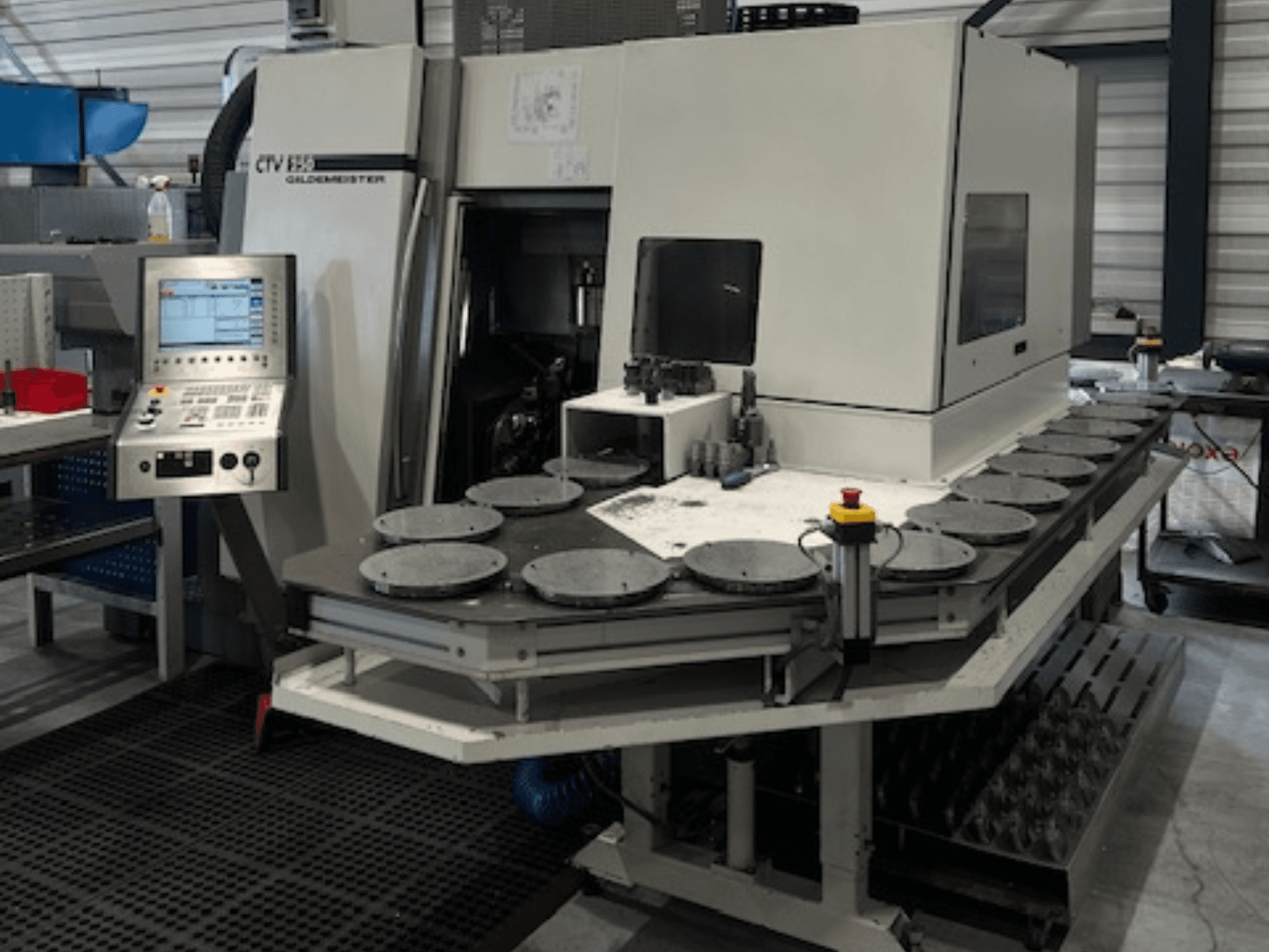 Alt-Text: CTV E33 Goldmeister-Bearbeitungseinheit in einer Werkstatt, Vorderansicht, mit Bedienfeld und mehreren runden Arbeitsplattformen.