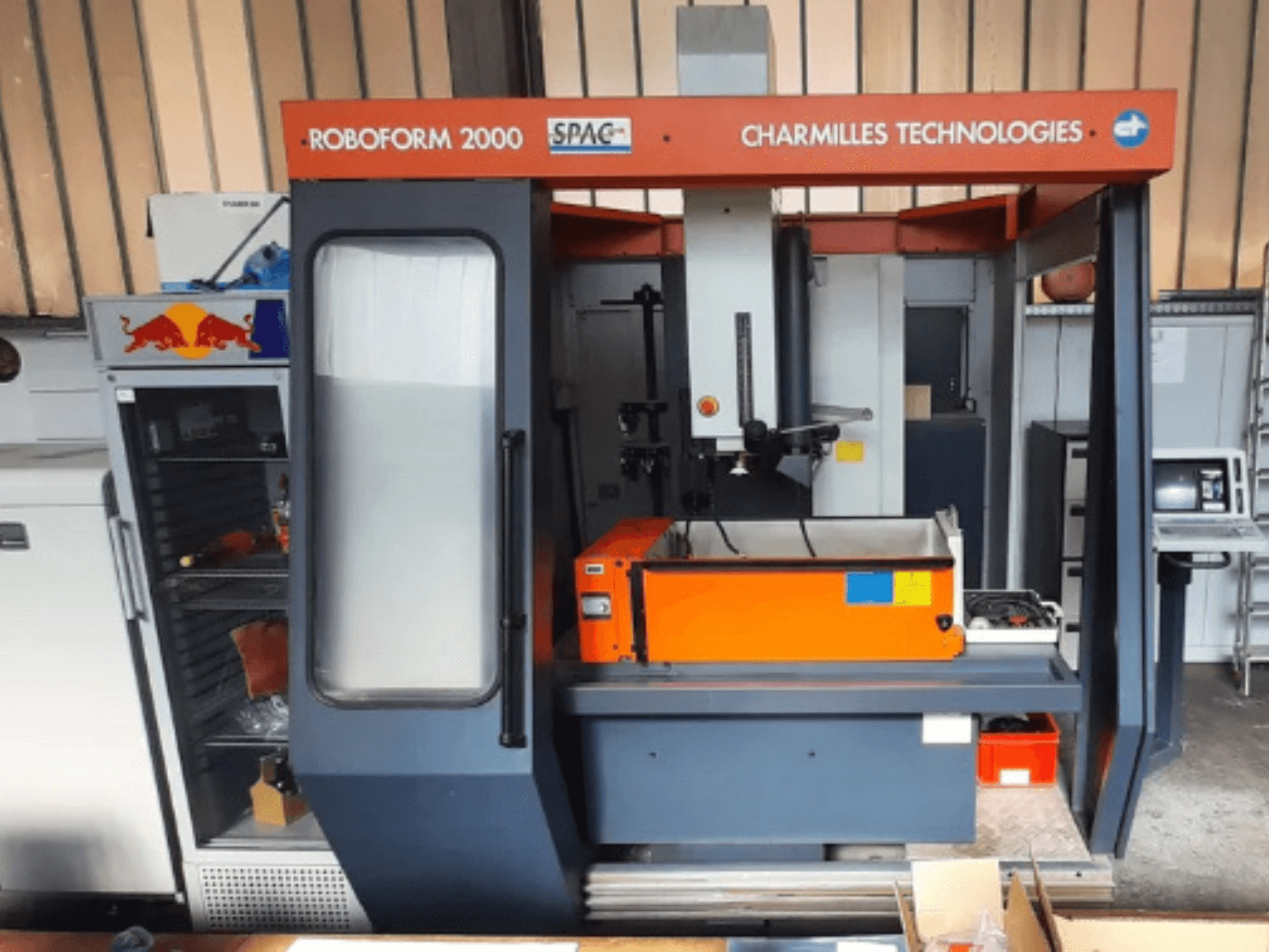 Senkerodiermaschine CHARMILLES Roboform 2000 in der Vorderansicht, mit orangefarbenem Arbeitstisch und Bedienfeld.