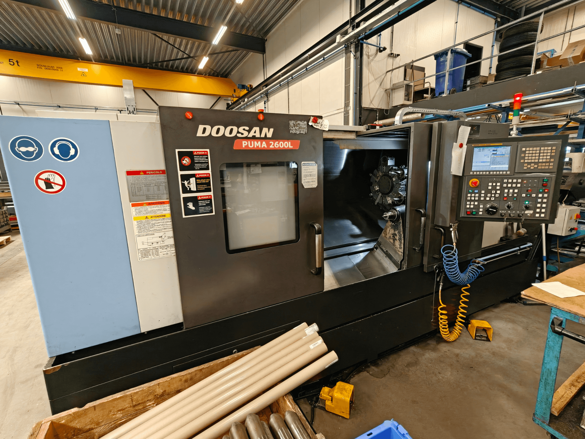 DOOSAN Puma 2600L Horizontaldrehmaschine in einer Werkstatt, Seitenansicht mit Bedienfeld und Spindelbereich.