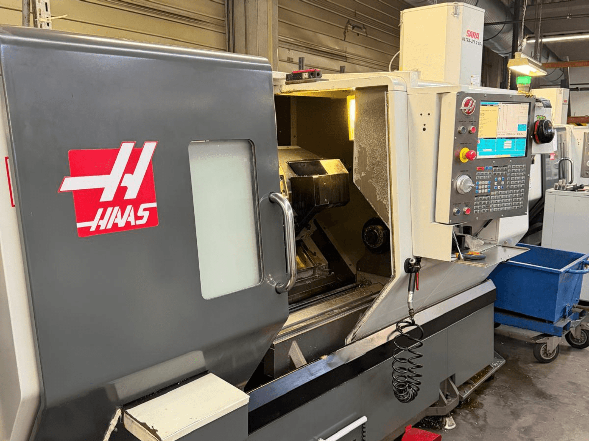 HAAS DS-30SSY Horizontal-Drehmaschine, Vorderansicht, mit Bedienfeld und internen Komponenten sichtbar, in Werkstattumgebung.