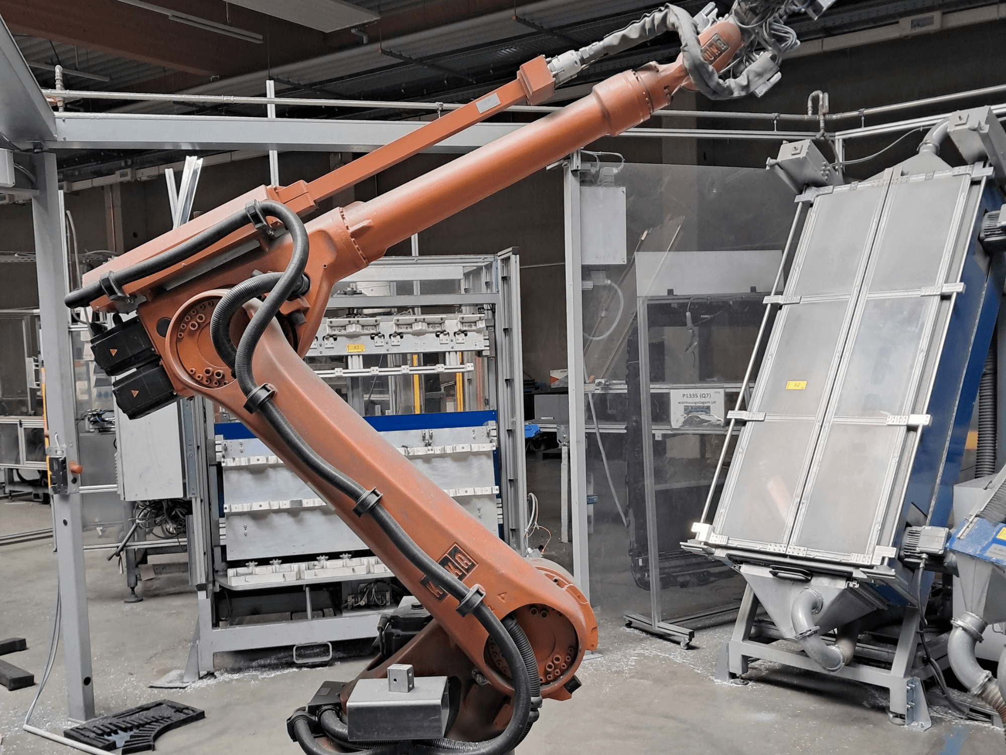 KUKA KR 30L16-2-Roboterarm in einer Fabrikumgebung, Seitenansicht mit Kabeln und mechanischen Bauteilen.