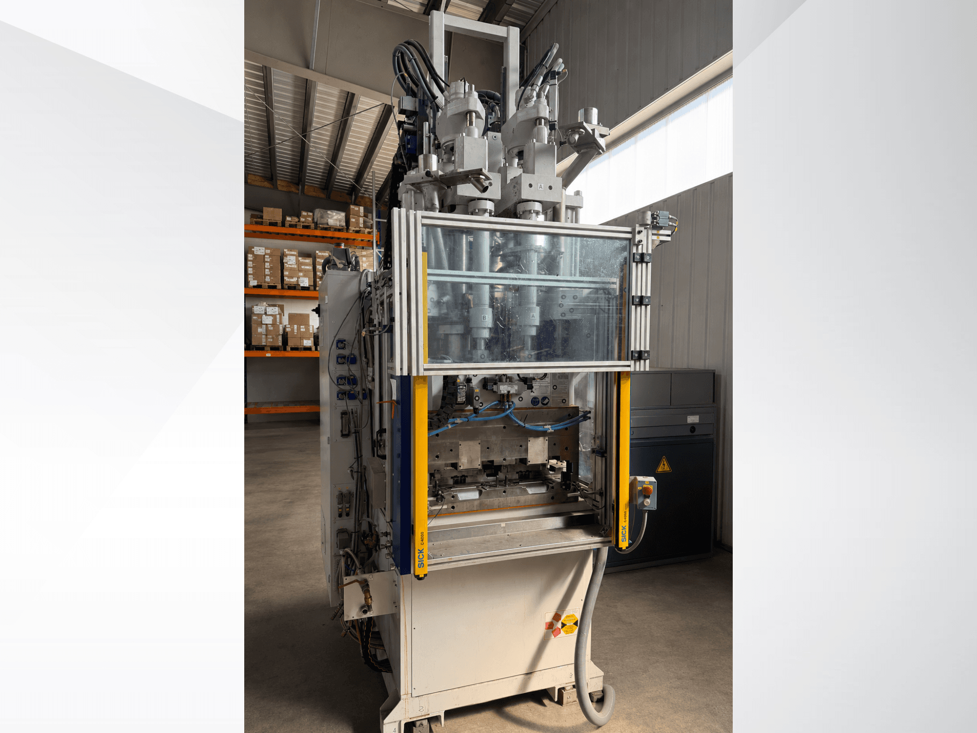 Vertikale Spritzgießmaschine Battenfeld CM 40, Vorderansicht mit transparenter Abdeckung, die das Bedienfeld und die Einspritzkomponenten zeigt.