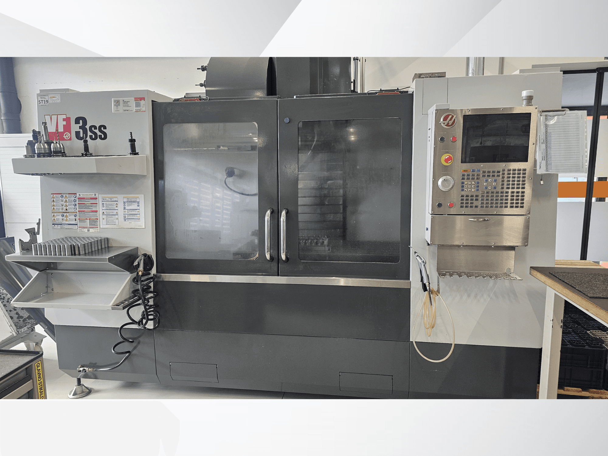 HAAS VF-3SS vertikales Bearbeitungszentrum, Vorderansicht, mit Bedienfeld, Werkzeugregal und großer Glastür.