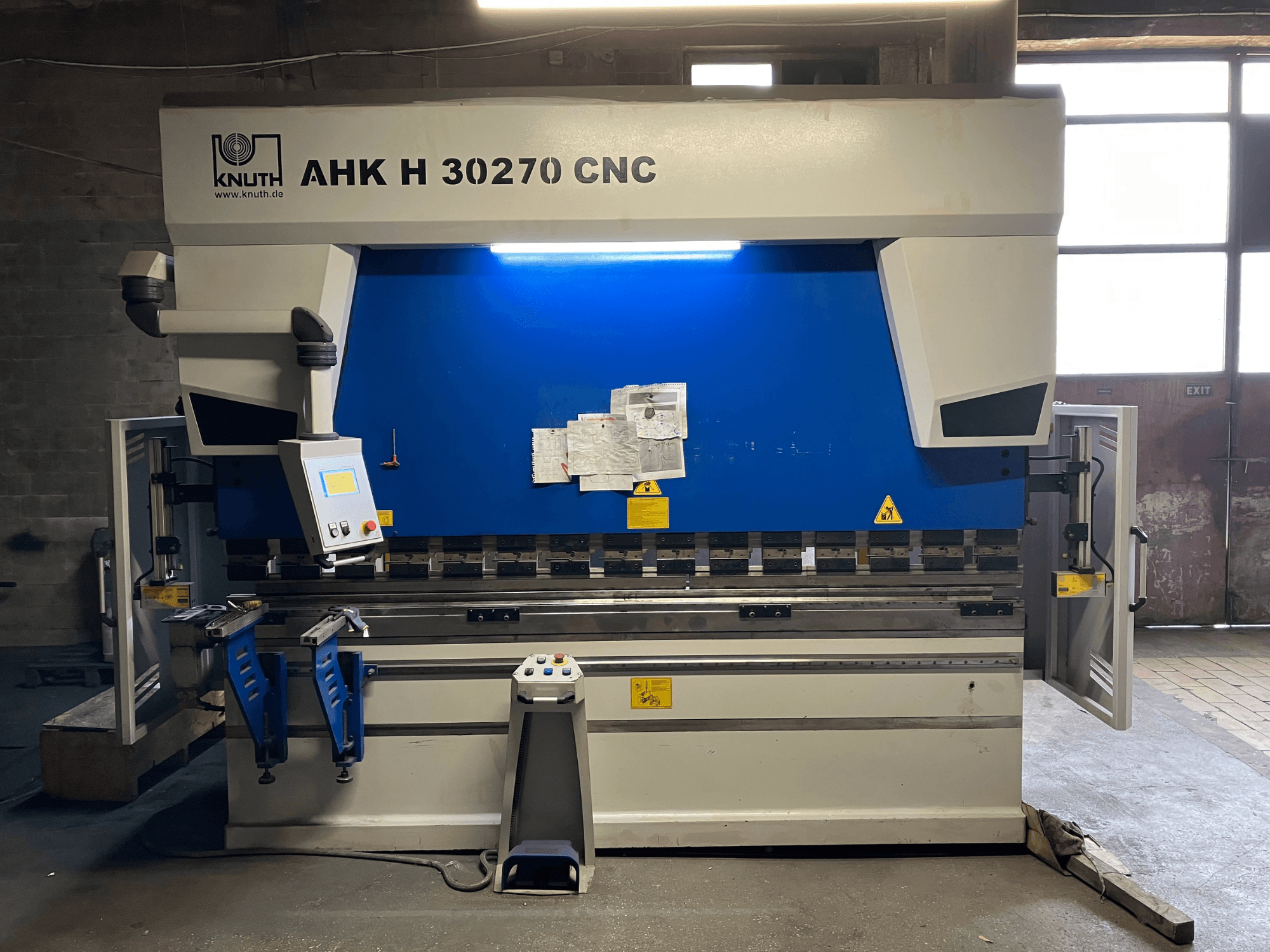 KNUTH AHK H 30270 CNC-Abkantpresse in einer Werkstatt, Vorderansicht, mit Blick auf das Bedienfeld und das blau-weiße Design, mit geöffneter Seitentür.