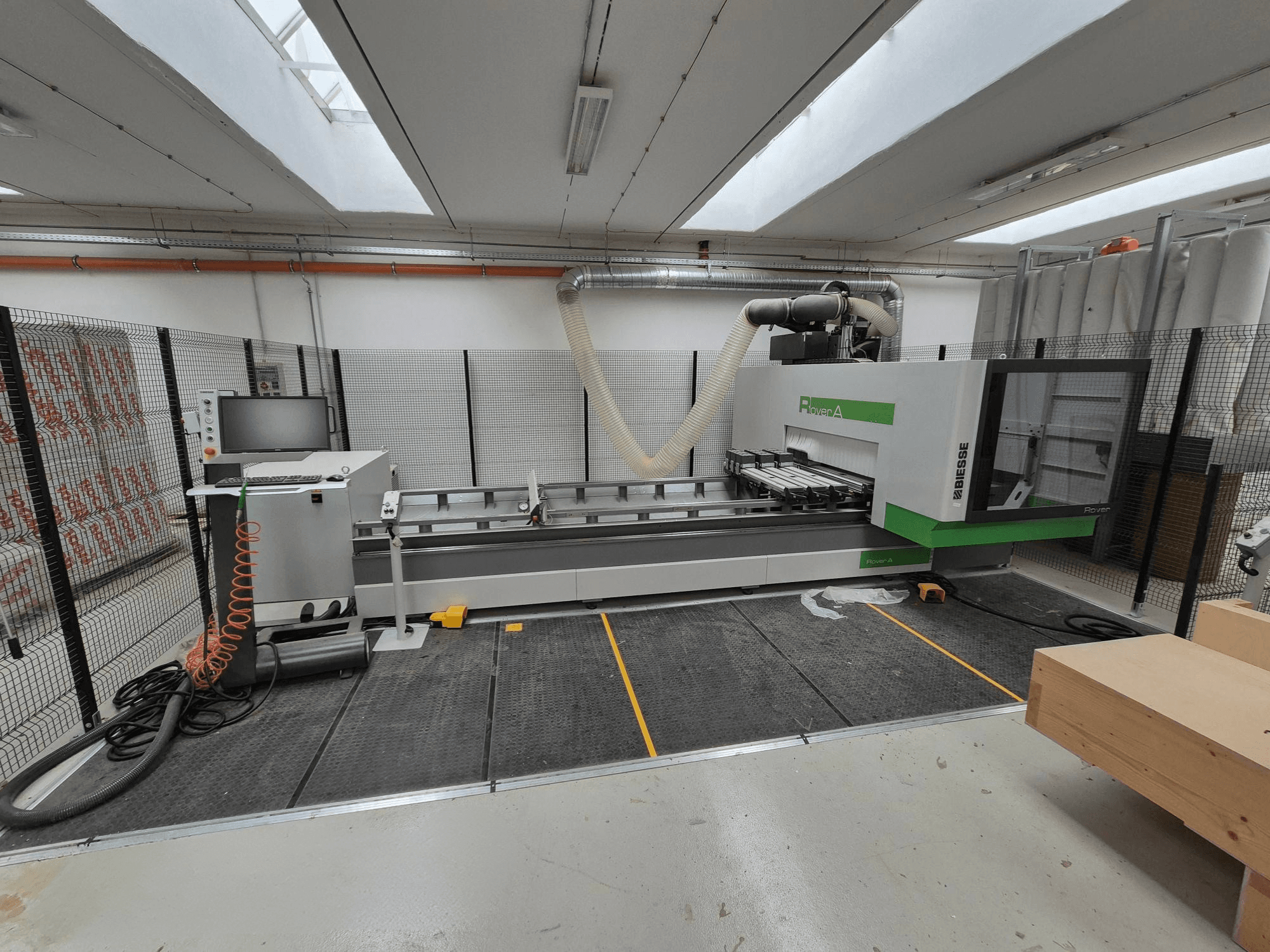 Biesse Rover Eine CNC-Maschine in einer Werkstatt, Vorderansicht. Mit einem Bedienfeld, einem Vakuumsystem und einer Arbeitsfläche.