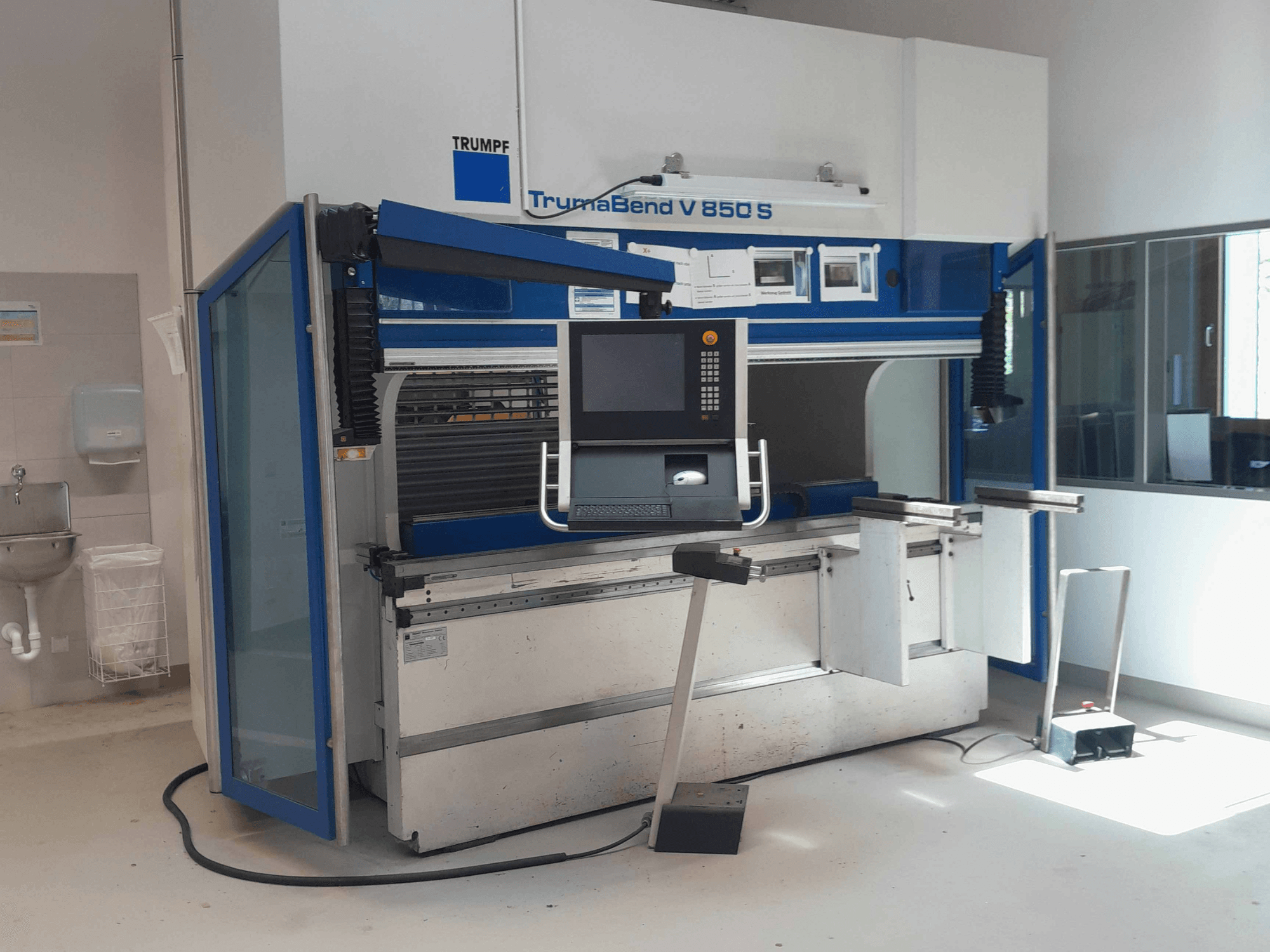 TRUMPF TrumaBend V 850 S Abkantpresse, Vorderansicht mit Bedienfeld und Sicherheitseinrichtungen in einem hellen Arbeitsbereich.