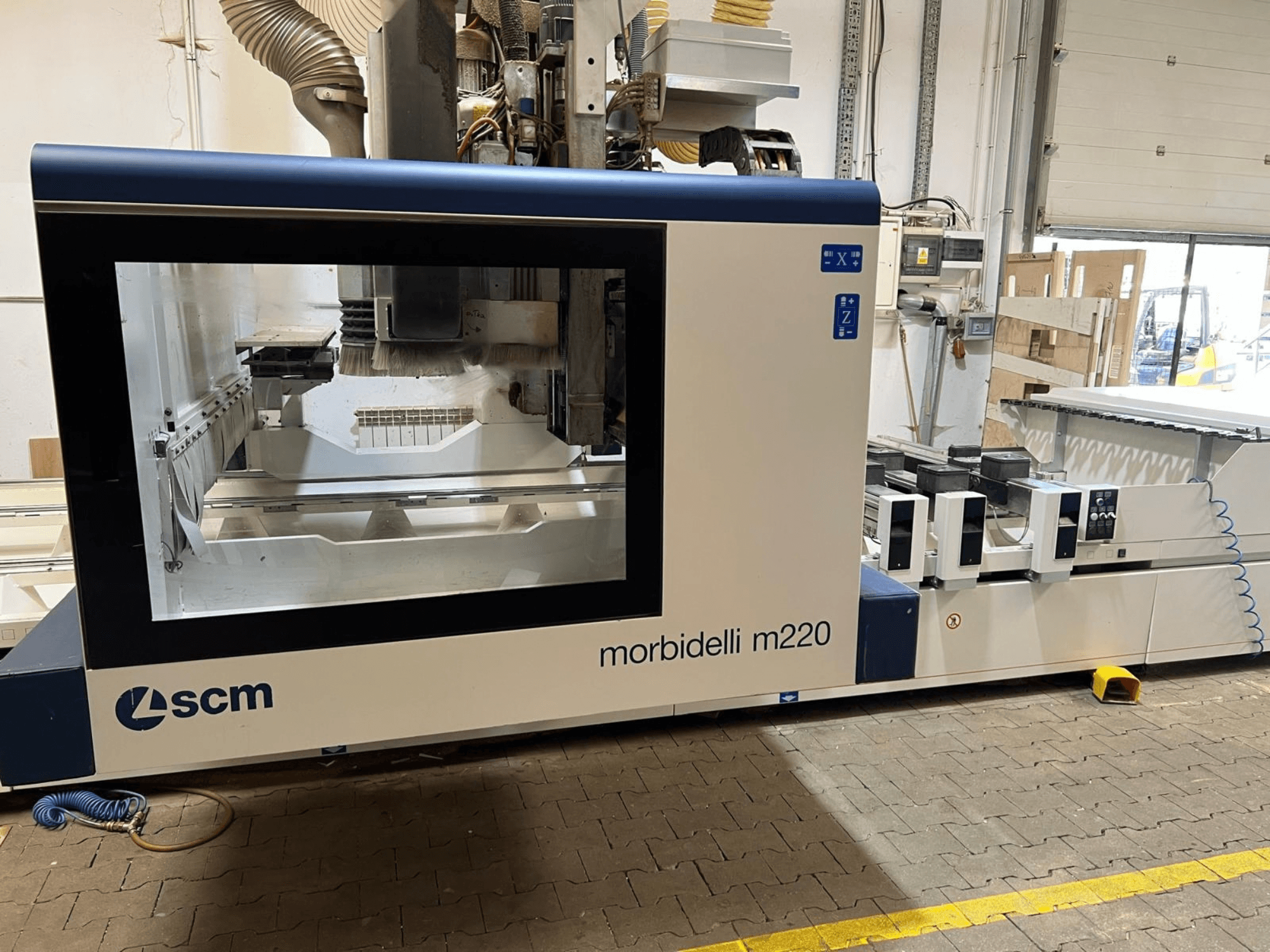 Vorderansicht des CNC-Bearbeitungszentrums SCM Morbidelli M220 mit großem Sichtfenster, Bedienfeld und Arbeitsbereich.