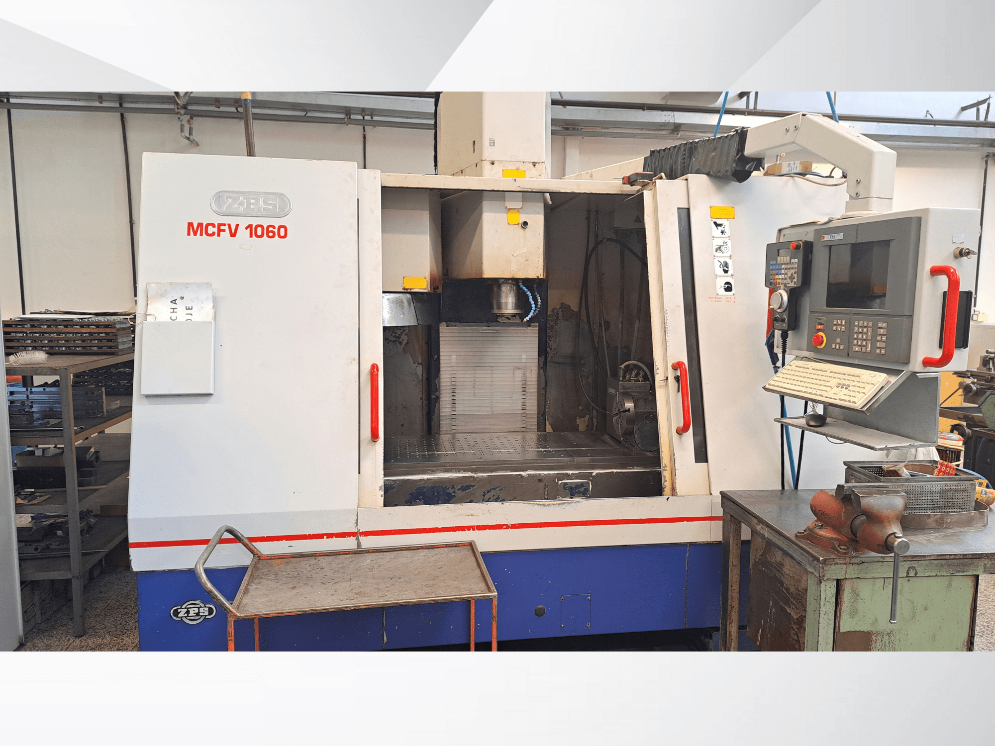 ZPS MCFV 1060 CNC-Maschine in einer Werkstatt, Vorderansicht mit Bedienfeld, Spindel und Arbeitsbereich; Farben: metallisches Grau und Blau.