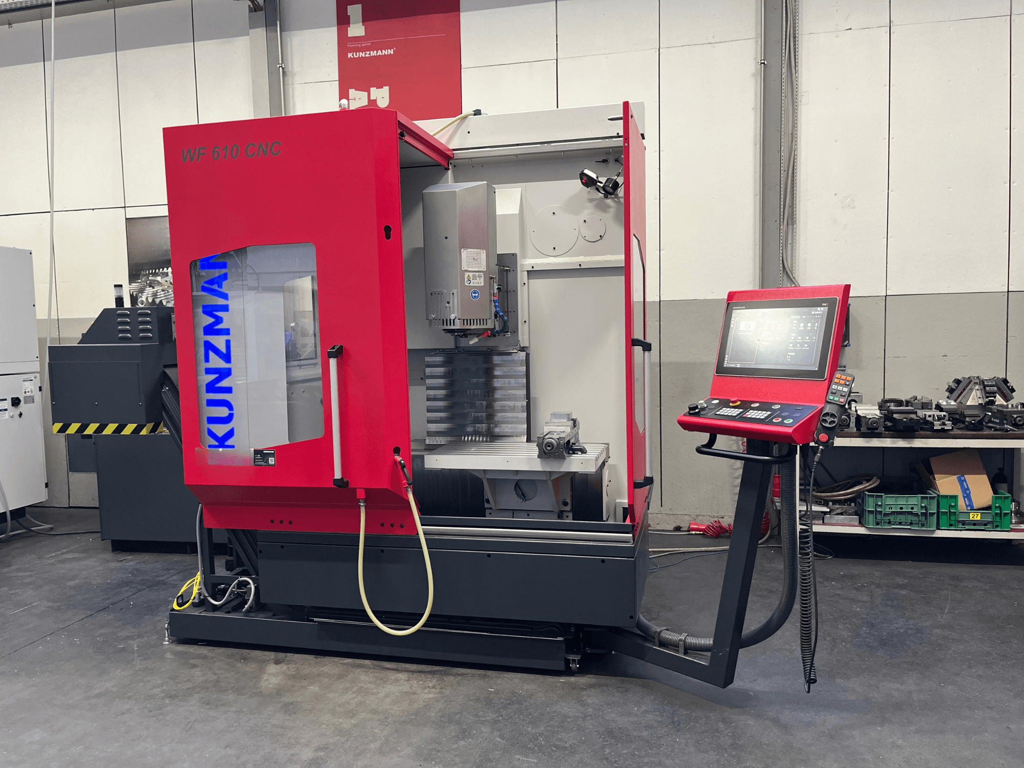 Vertikales CNC-Bearbeitungszentrum KUNZMANN WF 610 in einer Werkstatt, mit Bedienfeld und sichtbaren Maschinenkomponenten.