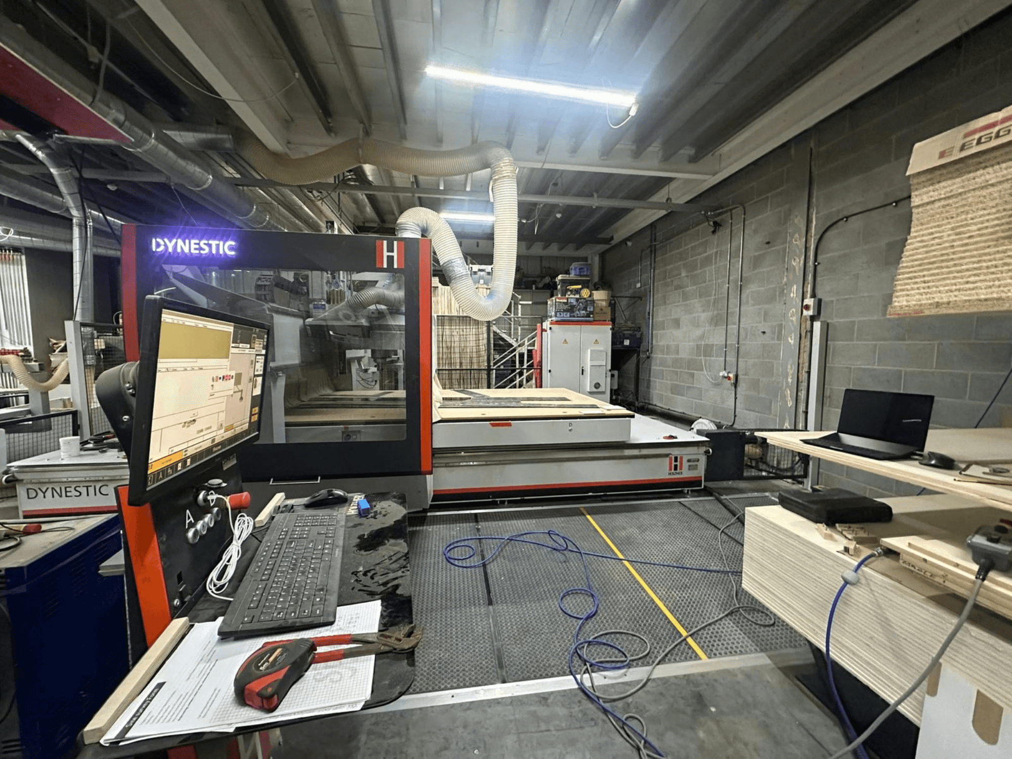 HOLZHER Dynestic 7535 Holzfräse in der Werkstatt, mit Bedienfeld, Monitor und Materialien auf dem Arbeitstisch, Vorderansicht.