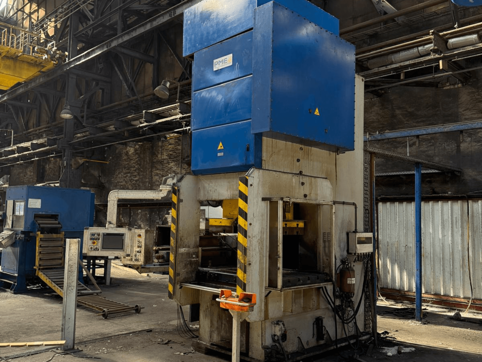 Mechanische Stanzpresse PME PE 400-1700 C, Vorderansicht, mit blauem Oberteil und gelb gestreiftem Sockel in einer Fabrikumgebung.