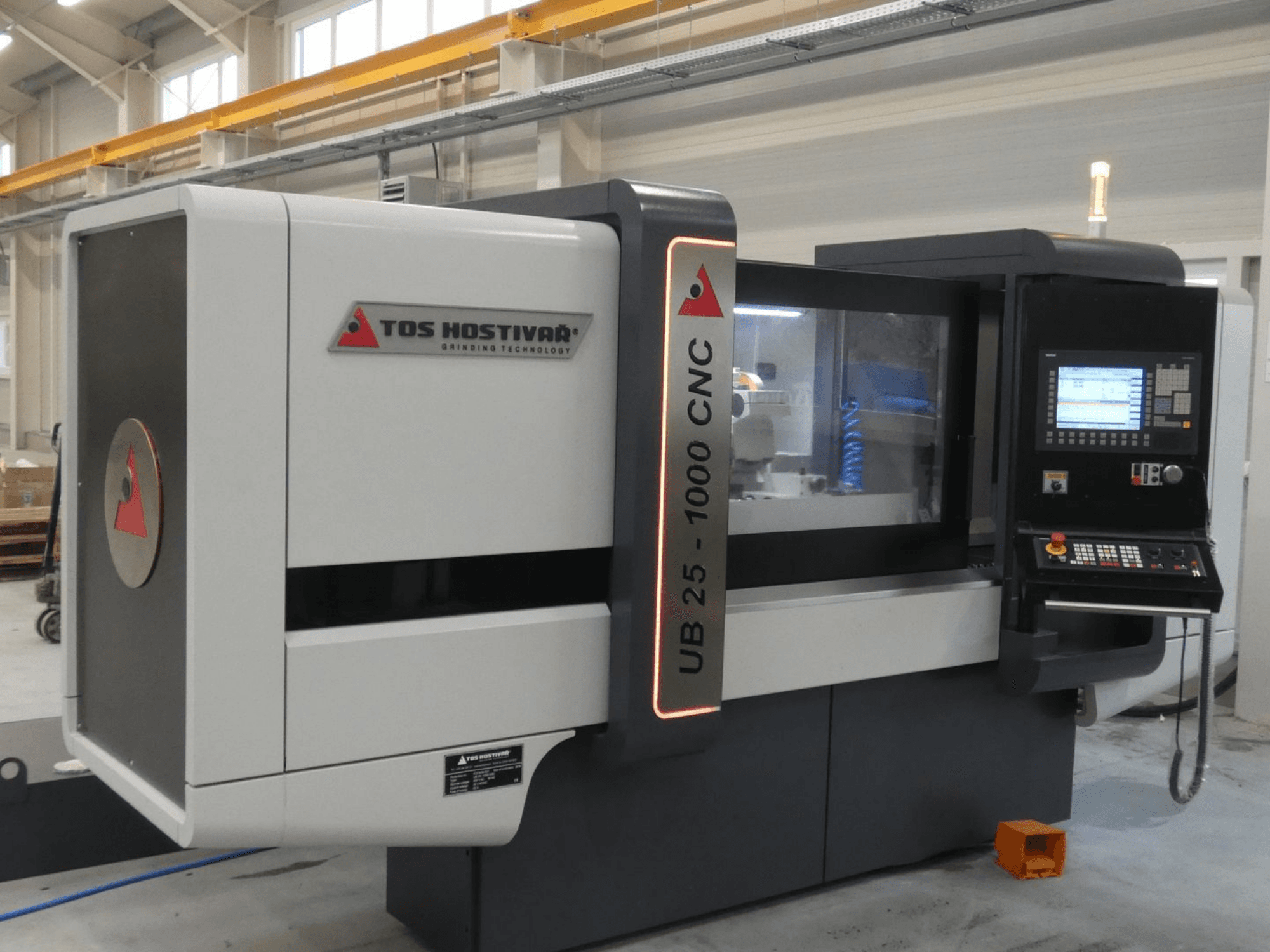 Zylinderschleifmaschine TOS HOSTIVAR UB 25-1000/C in der Vorderansicht, mit Bedienfeld und Schleifscheibe.