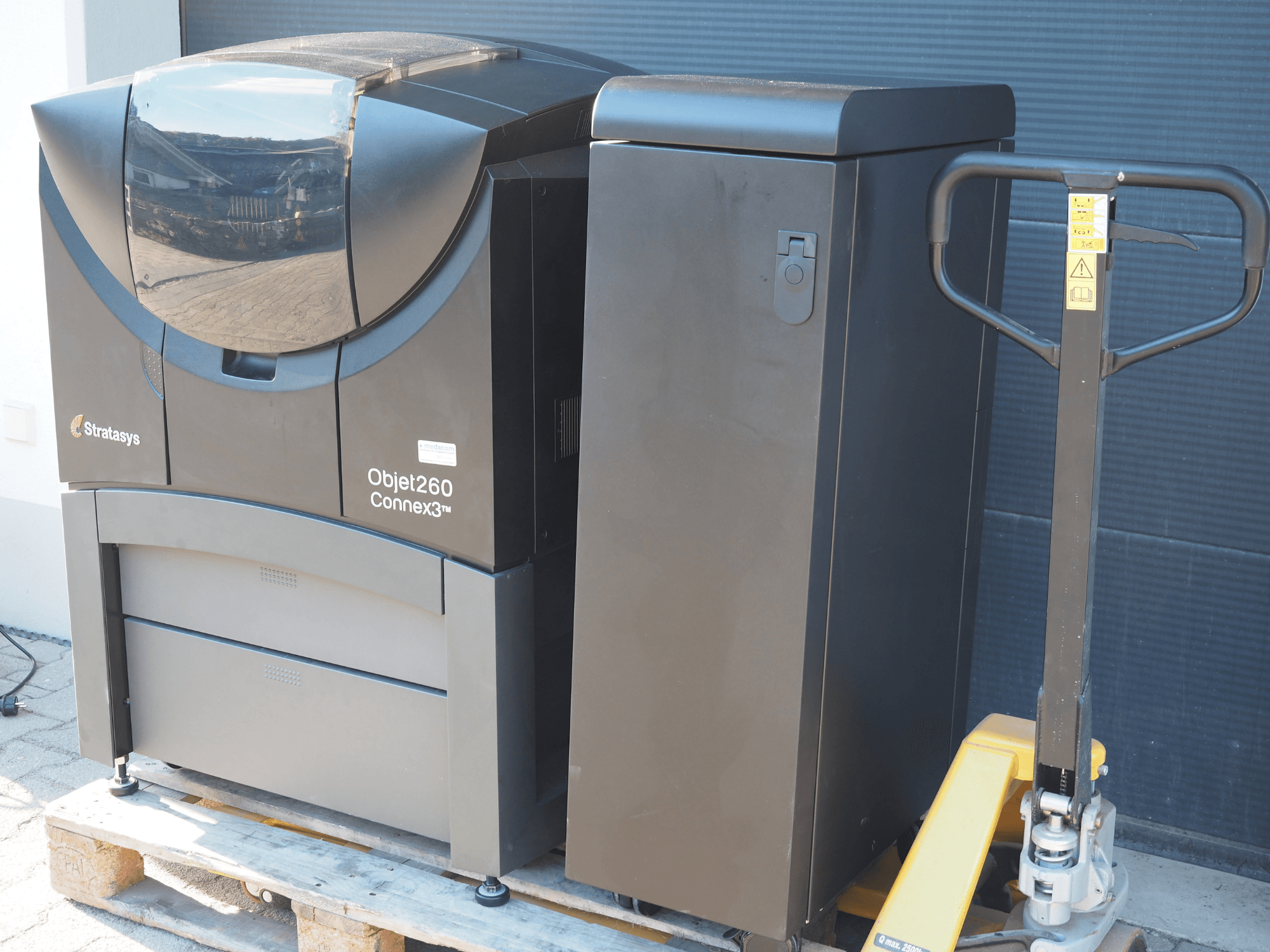 Stratasys Objet260 Connex3 Kunststoff-3D-Drucker, Seitenansicht, mit kompaktem Design, Bedienfeld und angeschlossenem Materialbehälter.