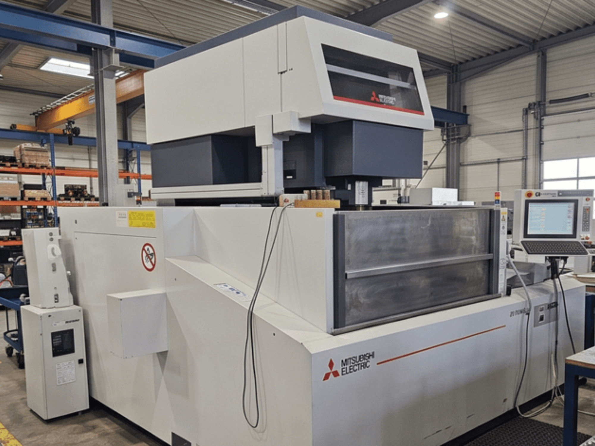 Mitsubishi MV-4800 Drahterodiermaschine, Vorderansicht, mit Blick auf das Bedienfeld und den Arbeitsbereich in einer Fabrikumgebung.