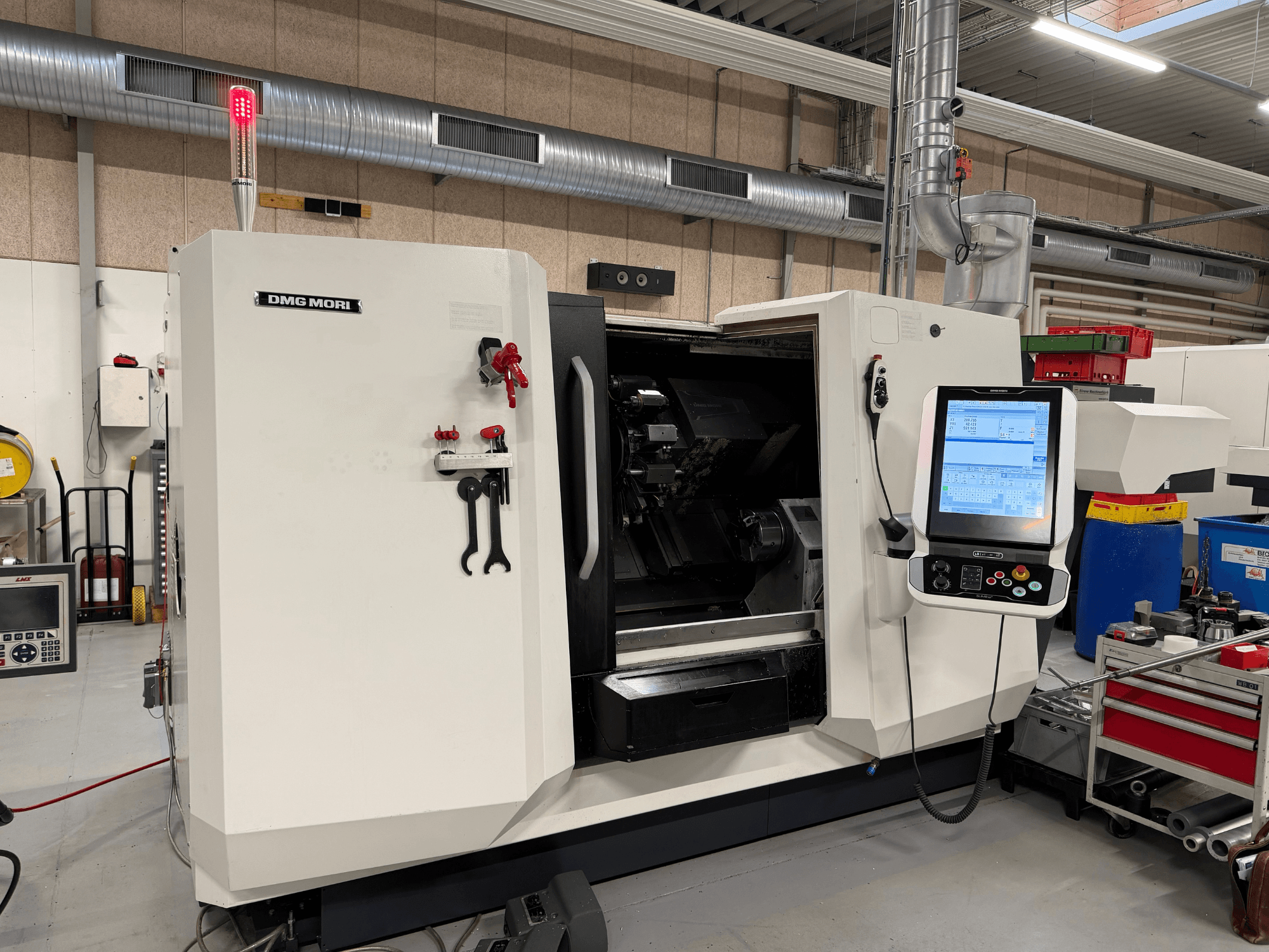 Horizontaldrehmaschine DMG MORI CLX 450 V6, Vorderansicht mit sichtbarem Bedienfeld, Not-Aus-Schalter und Sicherheitsleuchte.