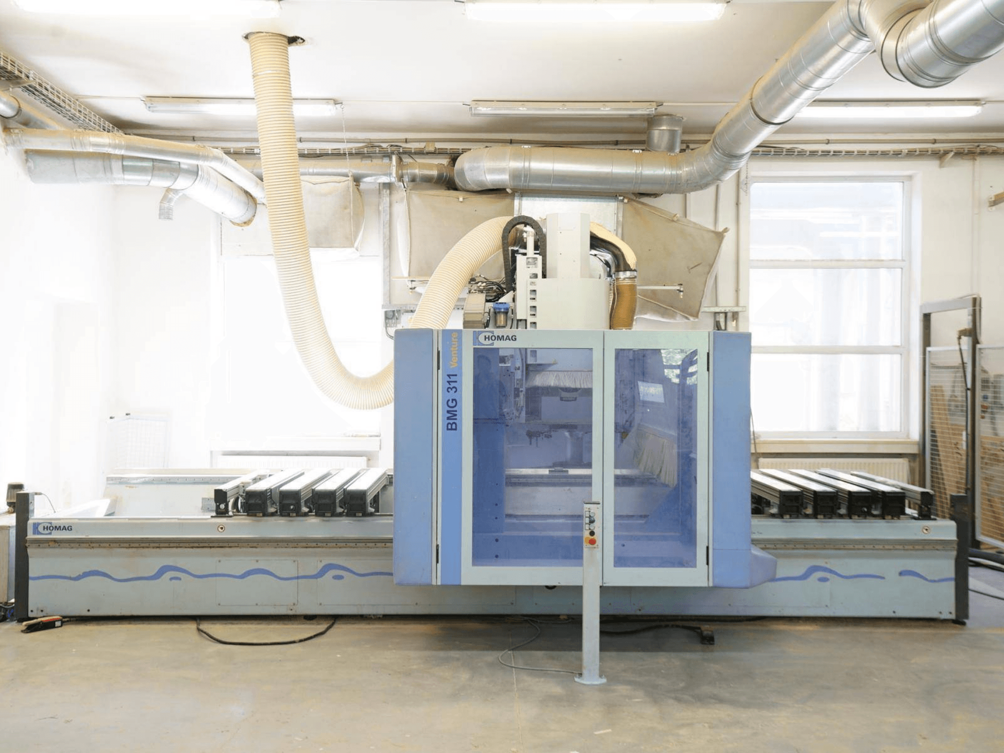 CNC-Holzbearbeitungszentrum HOMAG V BMG 311/42/F/K, Vorderansicht, mit großem Arbeitstisch und Staubabsaugung.