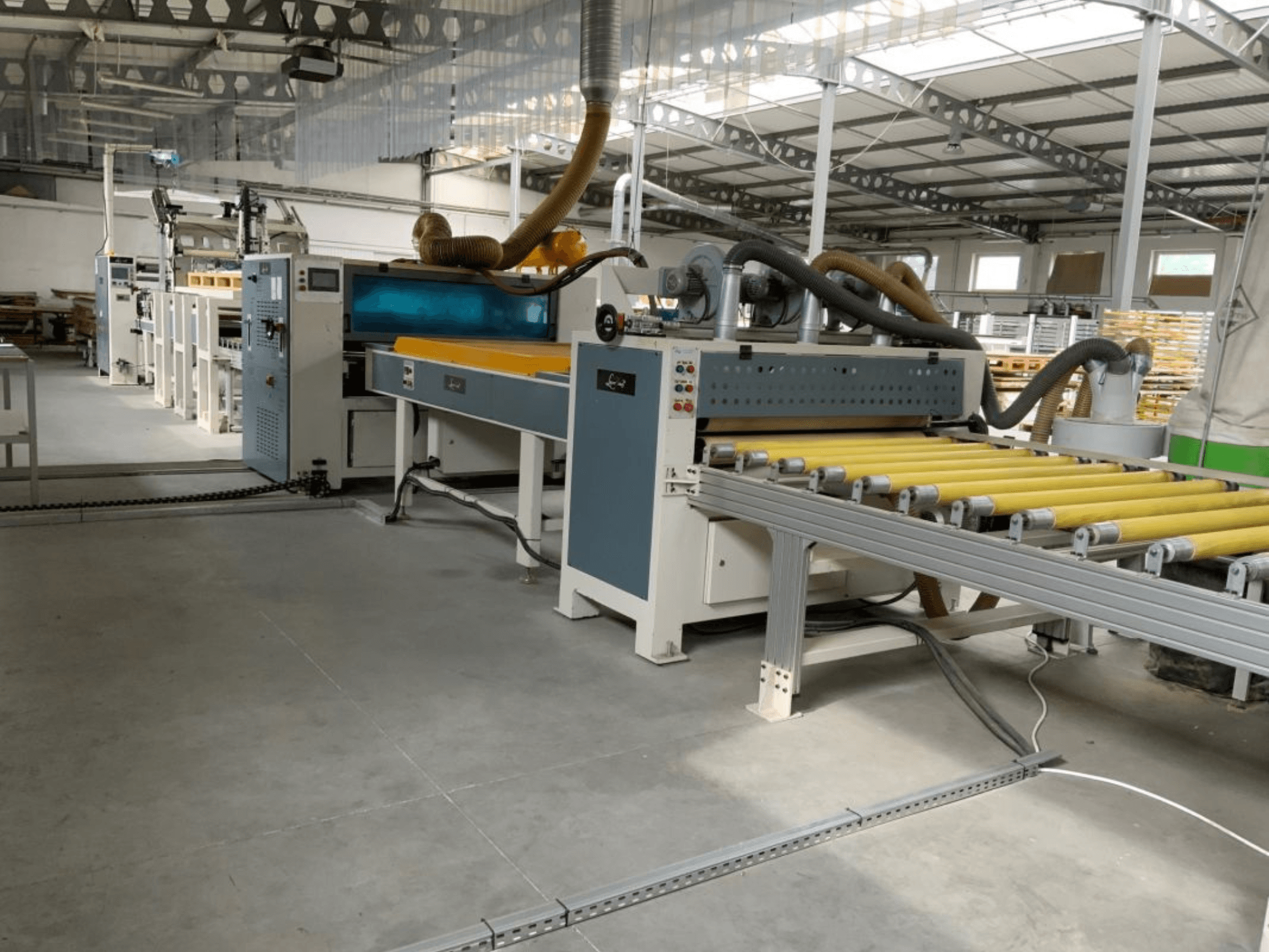 Laminierpresse MASTER PUR-1400 in einer Fabrikumgebung, Vorderansicht, mit Walzen und Bedienelementen.