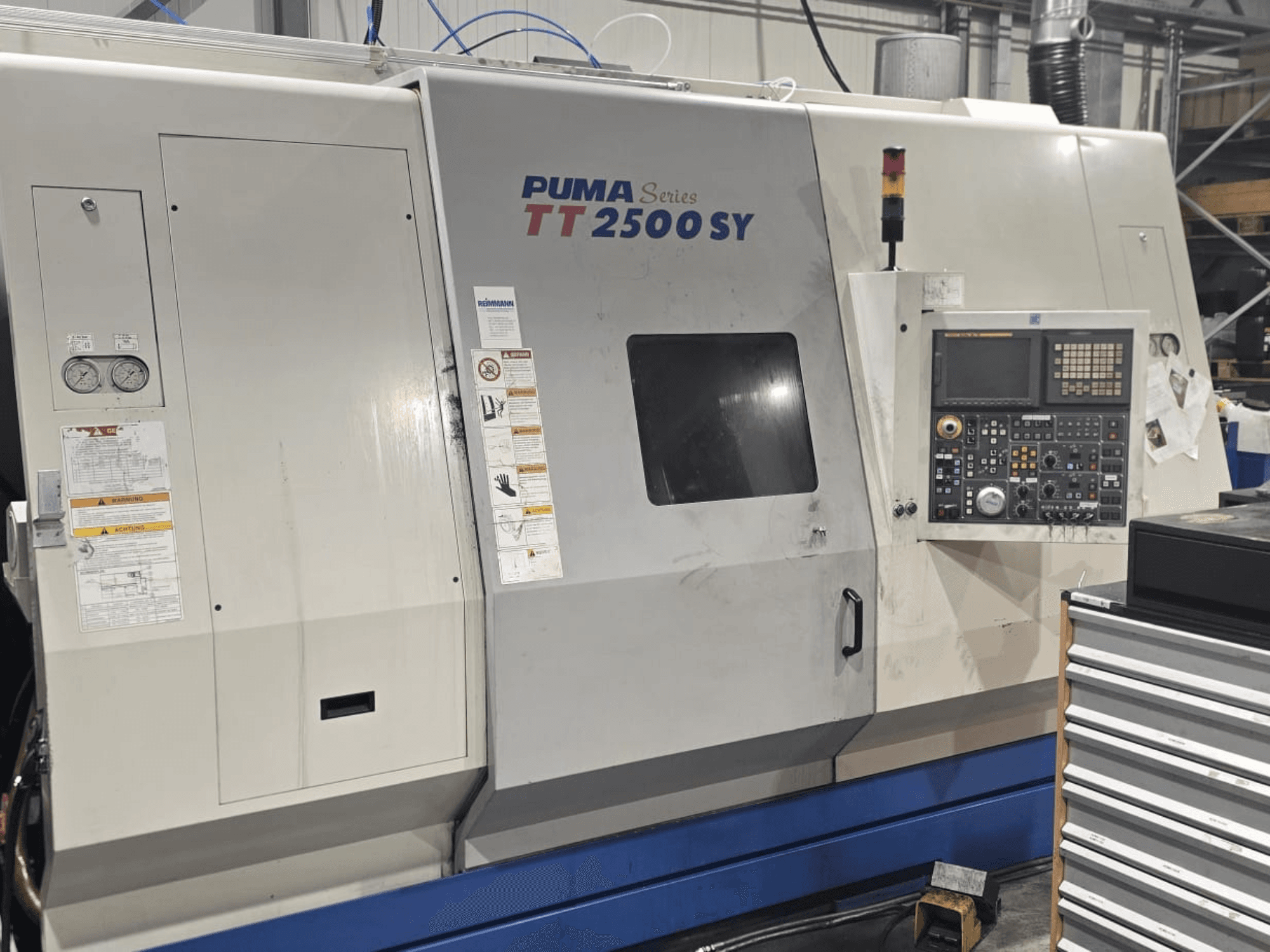 PUMA CNC-Drehmaschine der Serie TT 2500 SY, Vorderansicht; Bedienfeld mit Zifferblättern und Tasten, Lehren und Betriebsetiketten sichtbar.