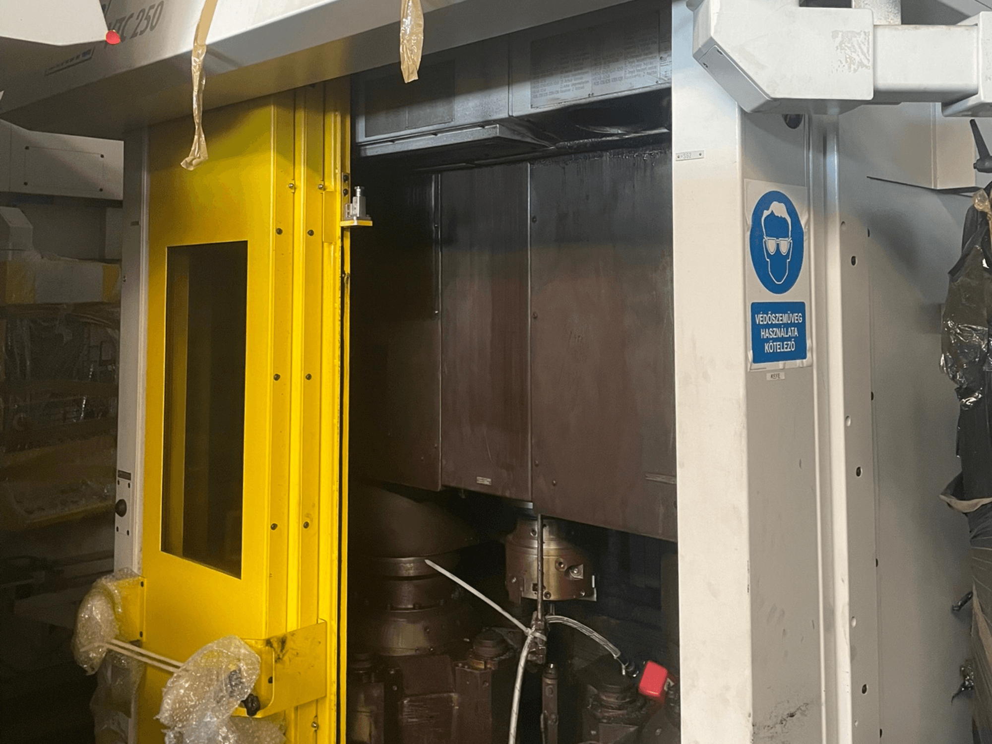 Gelbe Eingangstür einer Maschine mit Sicherheitszeichen, Vorderansicht einer Industriemaschine Modell Z250, mit Darstellung der inneren Komponenten.