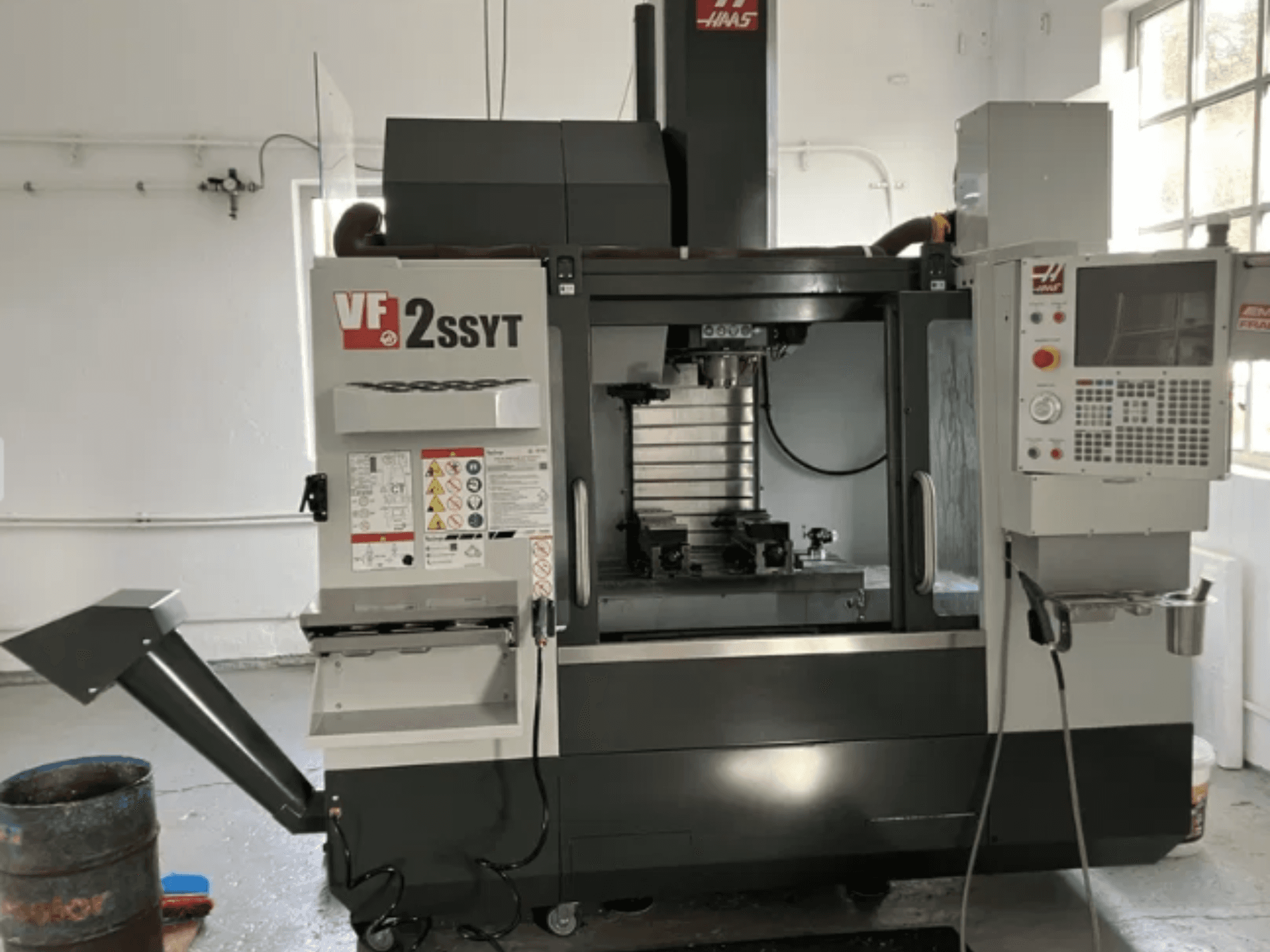Haas VF-2SSYT CNC-Fräse, Vorderansicht, mit Bedienfeld, Werkzeughalter und Kühlmittelsystem für die Metallbearbeitung.