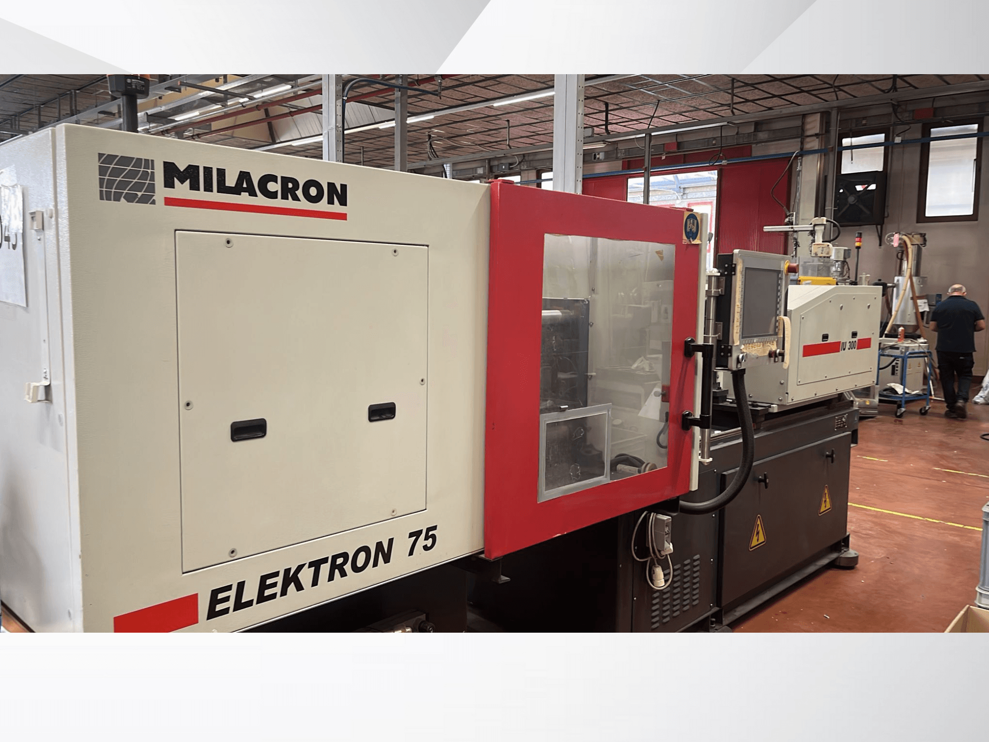 Milacron Elektron 75 Spritzgießmaschine in einer Werkstattumgebung, Seitenansicht mit Bedienfeld und mechanischen Teilen.