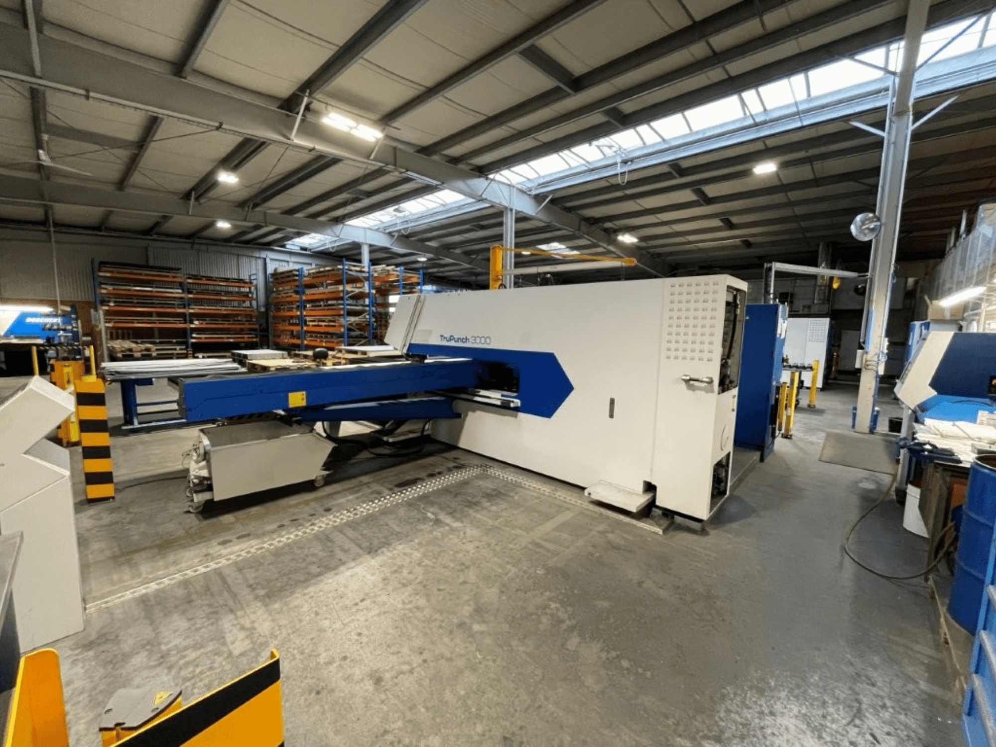 Die CNC-Stanzmaschine TRUMPF TruPunch 3000 in einer Fabrikumgebung – die Vorderansicht zeigt ihr blau-weißes Design und die Betriebskomponenten.