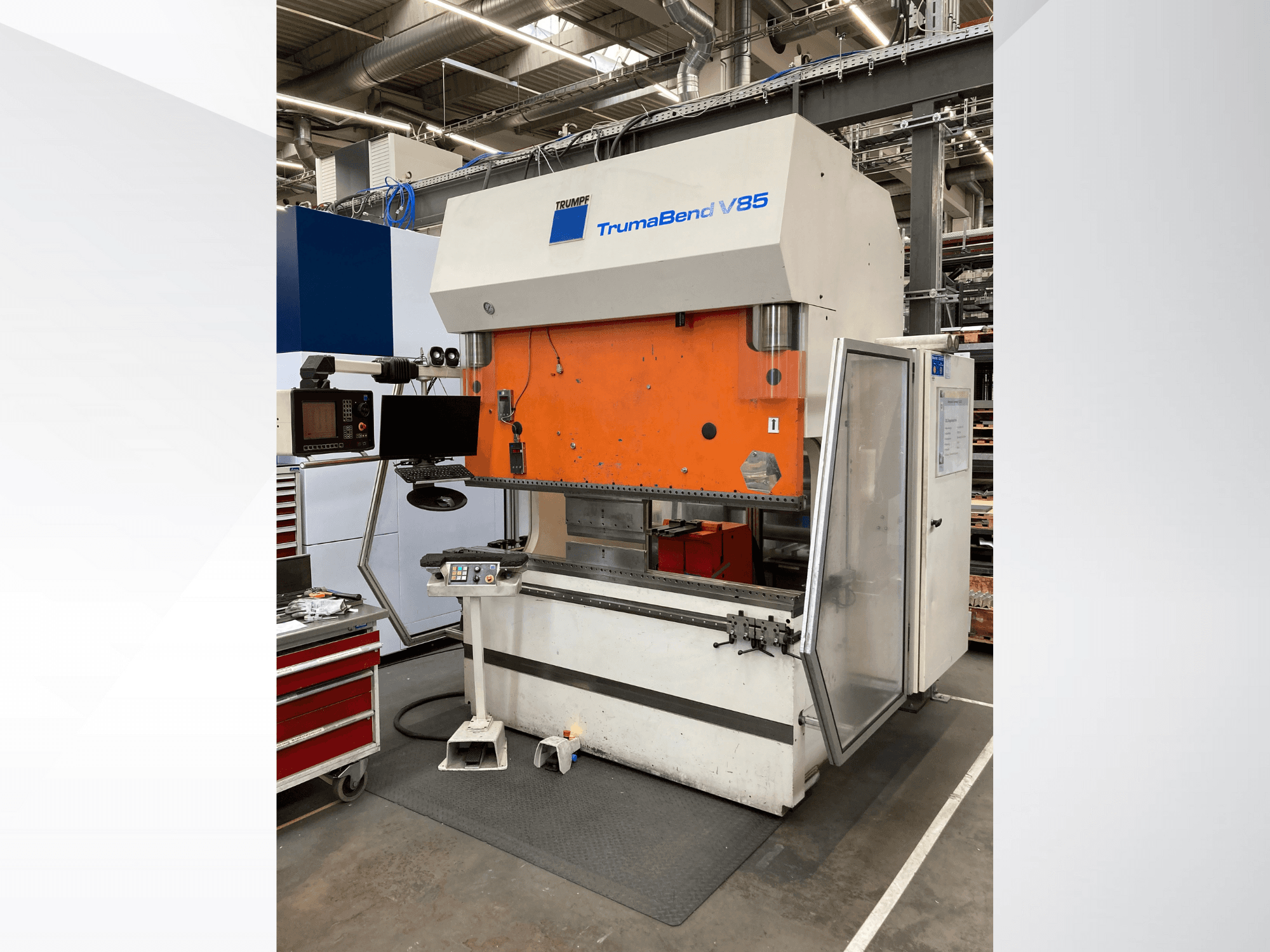 TruMatic V85 Biegemaschine in einer Fabrik, mit orangefarbener Frontplatte, Steuerungsbildschirm und offener Seitentür, Seitenansicht.