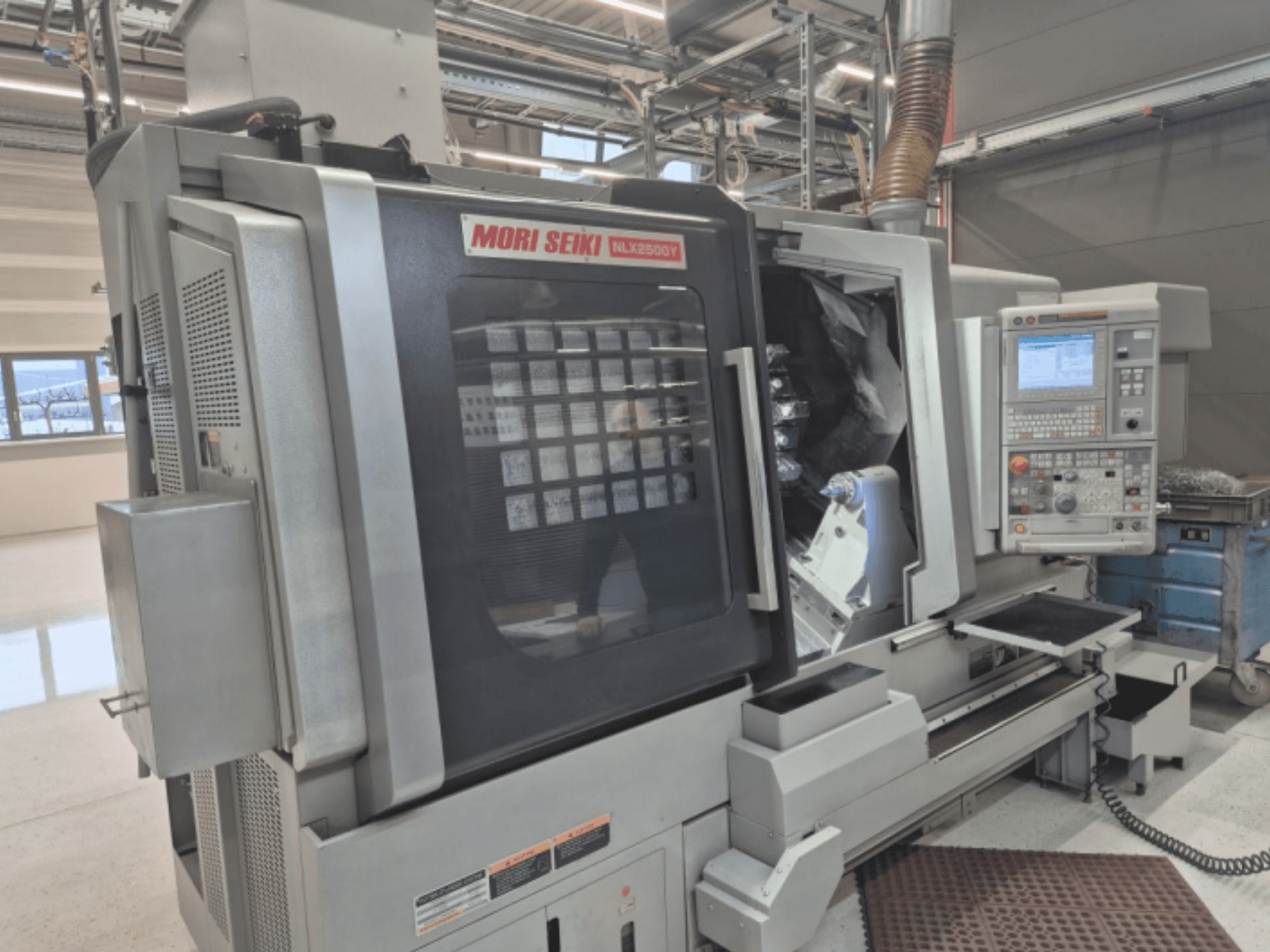 MORI SEIKI NL2500Y CNC-Drehmaschine in einer Werksumgebung, Vorderansicht mit Bedienfeld und Werkstückkammer.