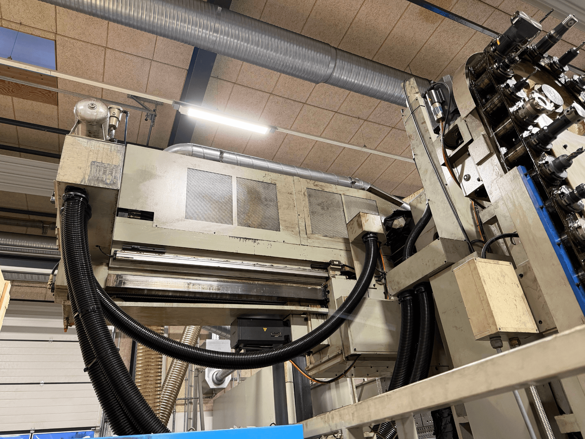 Alt-Text: KIHEUNG KNC-U1000 Universal-Bearbeitungszentrum in der Seitenansicht, mit Maschinenkomponenten und Rohren.