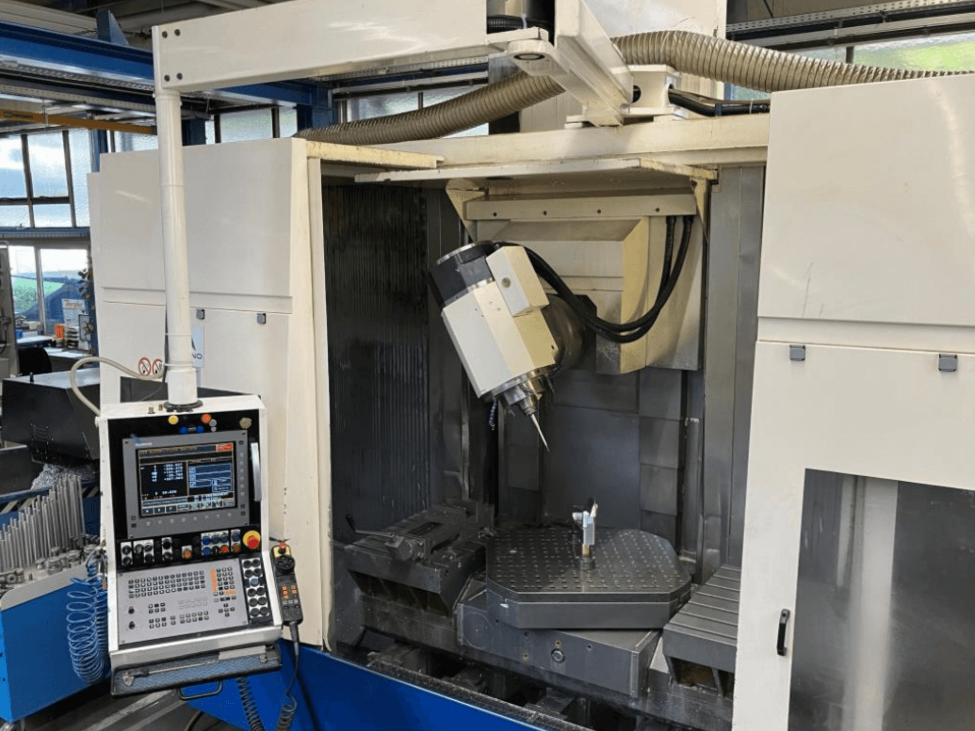 Huron EX-C Universal-Bearbeitungszentrum, Vorderansicht, mit Bedienfeld, Spindelkopf und Werkstückeinrichtung auf dem Tisch.