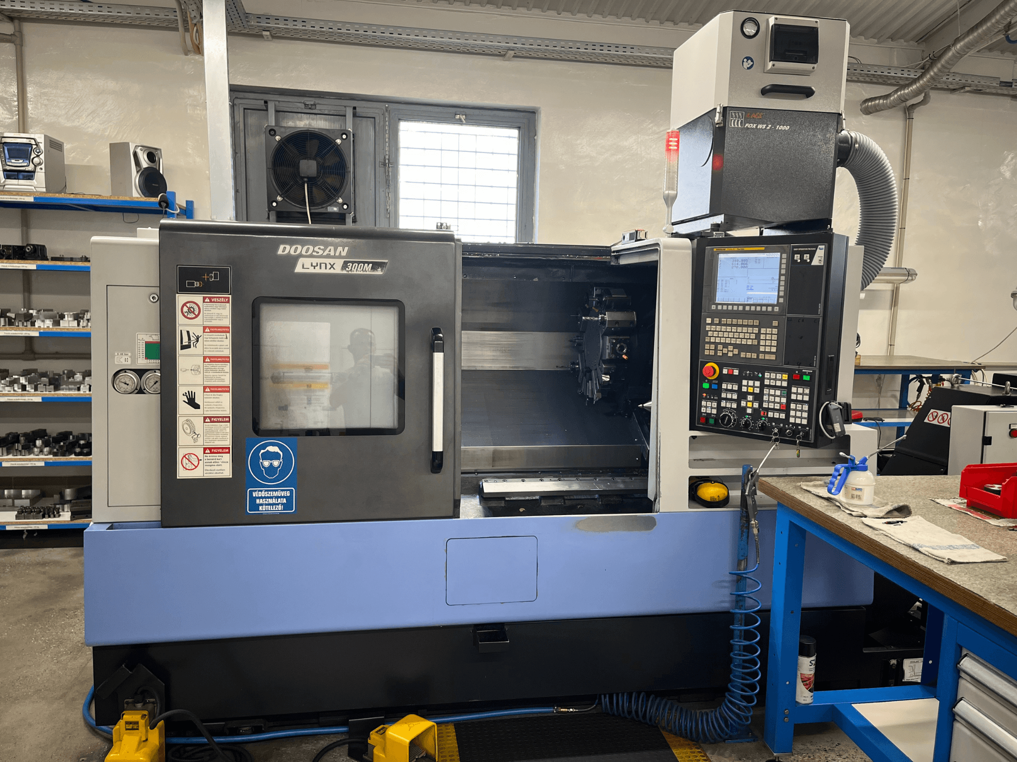 Horizontaldrehmaschine DOOSAN LYNX 300M, Vorderansicht, mit Bedienfeld und Betriebskomponenten.